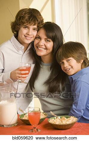 Stock Image - Hispanic mother and sons eating breakfast. Fotosearch