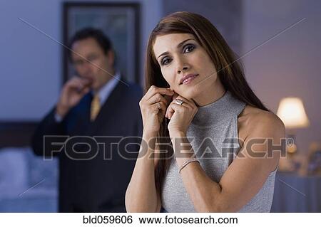 Stock Photograph - Hispanic woman fastening earring. Fotosearch