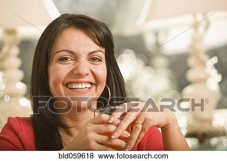 Hispanic woman holding glass View Large Photo Image Stock Photo - Hispanic woman holding glass. Fotosearch