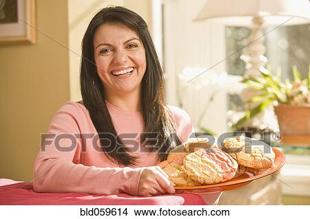 Hispanic woman holding plate of cookies View Large Photo Image Picture - Hispanic woman holding plate of cookies. Fotosearch
