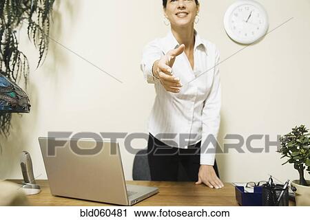 Stock Image - Mixed Race businesswoman offering hand to shake. Fotosearch