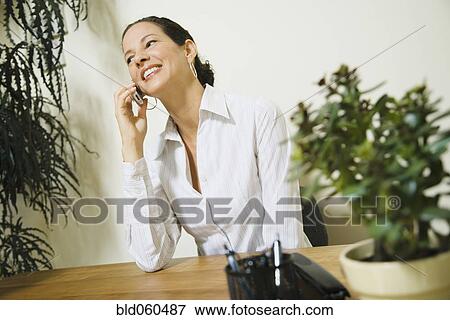 Mixed Race businesswoman talking on cell phone View Large Photo Image Stock Photo - Mixed Race businesswoman talking on cell phone. Fotosearch