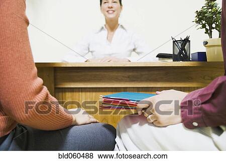 Stock Photo - Mixed Race businesswoman talking to clients. Fotosearch