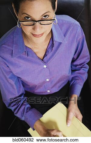 Stock Image - Mixed Race female psychiatrist holding notepad. Fotosearch