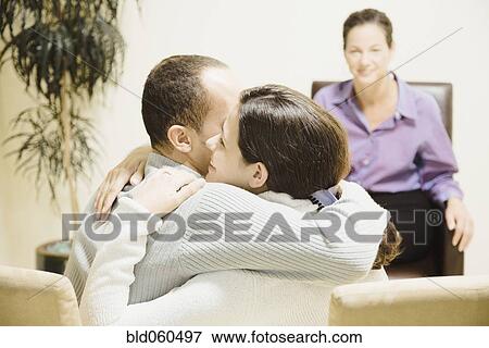 Multi-ethnic couple hugging at therapy session View Large Photo Image Stock Photo - Multi-ethnic couple hugging at therapy session. Fotosearch