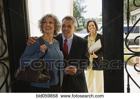 Stock Photo - Multi-ethnic couple looking at new house. Fotosearch