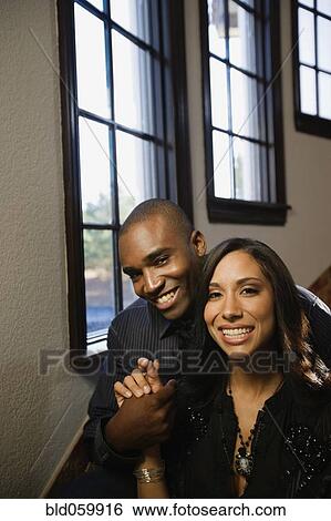 Multi-ethnic couple sitting next to windows View Large Photo Image Stock Photograph - Multi-ethnic couple sitting next to windows. Fotosearch
