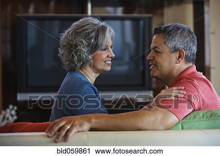 Stock Image - Multi-ethnic couple smiling at each other. Fotosearch