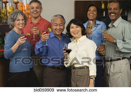 Multi-ethnic couple toasting with cocktails View Large Photo Image Stock Photo - Multi-ethnic couple toasting with cocktails. Fotosearch