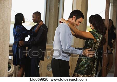 Stock Image - Multi-ethnic couples dancing at party . Fotosearch