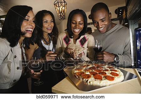 Multi-ethnic friends cooking pizza View Large Photo Image Stock Image - Multi-ethnic friends cooking pizza. Fotosearch