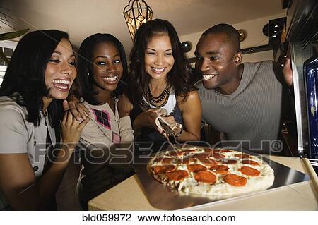 Multi-ethnic friends cooking pizza View Large Photo Image Stock Image - Multi-ethnic friends cooking pizza. Fotosearch