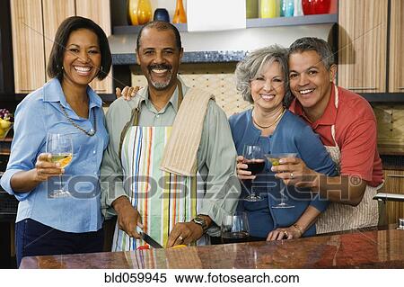 Stock Photography - Multi-ethnic friends drinking wine and preparing food. Fotosearch