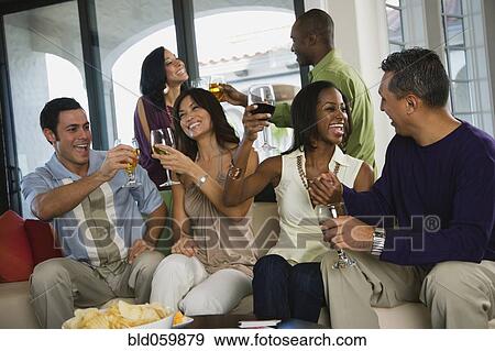 Stock Photo - Multi-ethnic friends toasting at party. Fotosearch