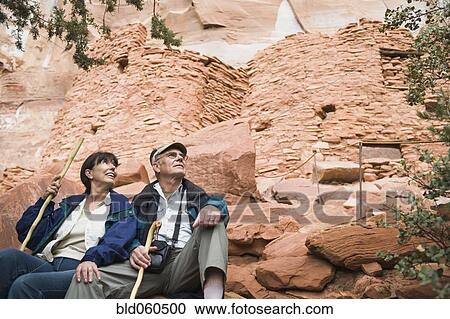 Stock Image - Multi-ethnic senior couple holding walking sticks. Fotosearch
