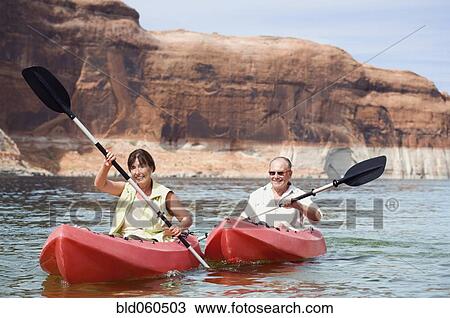 Stock Image - Multi-ethnic senior couple kayaking. Fotosearch