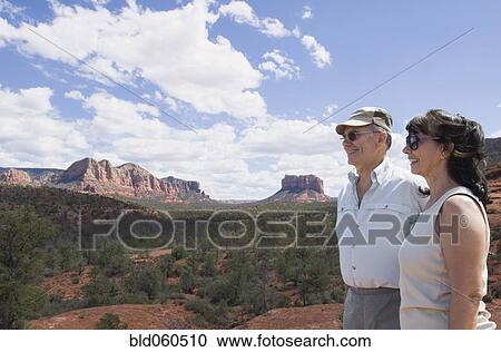 Stock Image - Multi-ethnic senior couple looking at desert landscape. Fotosearch