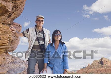 Multi-ethnic senior couple next to rocks View Large Photo Image Stock Image - Multi-ethnic senior couple next to rocks. Fotosearch