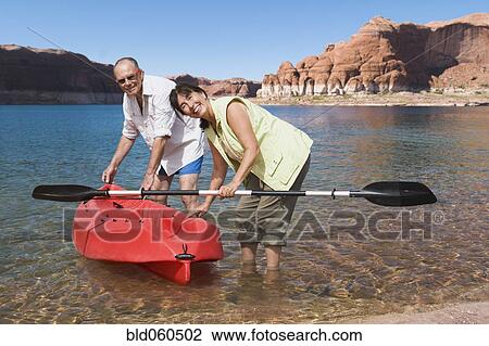Multi-ethnic senior couple next to kayak in water View Large Photo Image Stock Image - Multi-ethnic senior couple next to kayak in water. Fotosearch