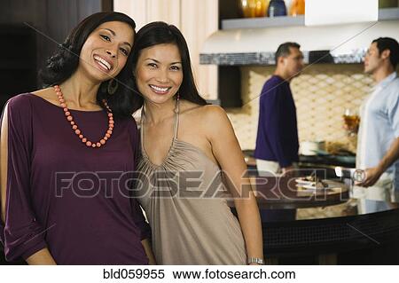 Multi-ethnic women hugging at party View Large Photo Image Stock Photography - Multi-ethnic women hugging at party. Fotosearch