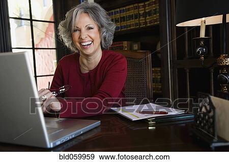 Woman laughing at desk View Large Photo Image Stock Photo - Woman laughing at desk. Fotosearch