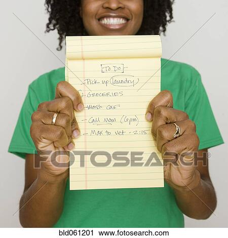 Stock Image - Africa woman holding to do list. Fotosearch