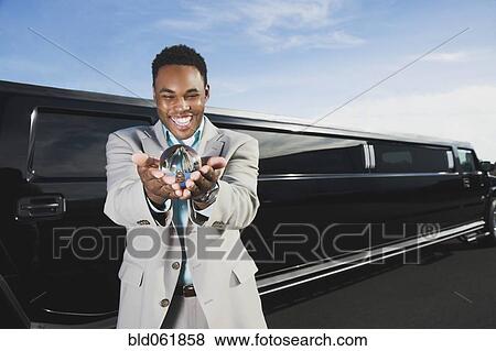 Stock Photo - African businessman holding crystal ball. Fotosearch