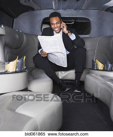 Stock Photography - African businessman reading newspaper. Fotosearch