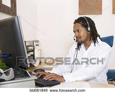 Stock Photo - African businessman wearing headset. Fotosearch