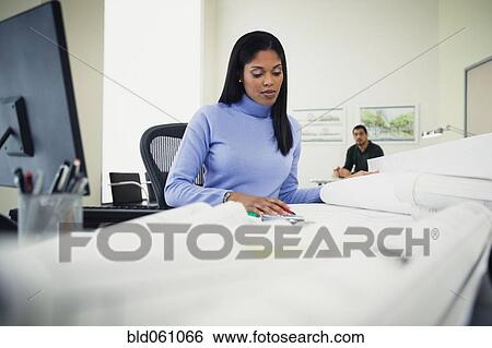 Stock Photograph - African businesswoman looking at blueprints. Fotosearch