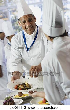 African chef handing plate of food View Large Photo Image Stock Image - African chef handing plate of food. Fotosearch