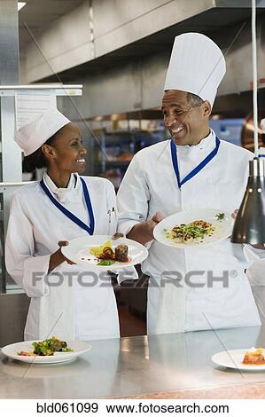 Stock Photo - African chefs holding plates of food. Fotosearch