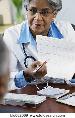 Stock Photo - African female doctor explaining electrocardiogram to patient. Fotosearch