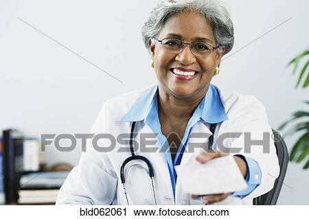 Stock Image - African female doctor holding a prescription. Fotosearch