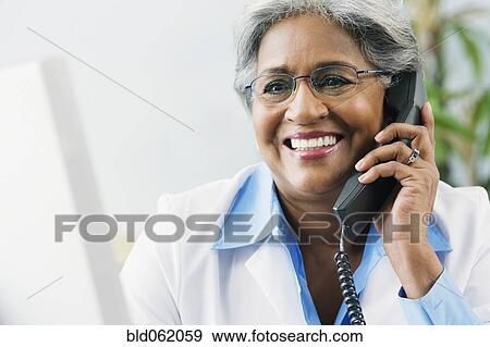 African female doctor talking on telephone View Large Photo Image Stock Photo - African female doctor talking on telephone. Fotosearch