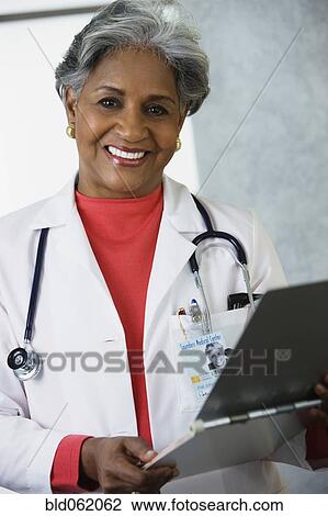 Stock Image - African female doctor with medical chart. Fotosearch