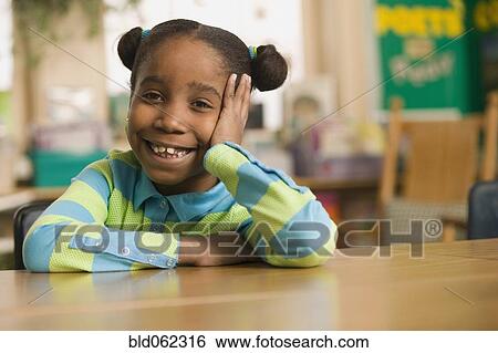 Stock Photograph - African girl in classroom with head in hands. Fotosearch