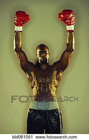 Stock Image - African male boxer with arms raised. Fotosearch