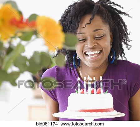 Picture - African next to birthday cake. Fotosearch
