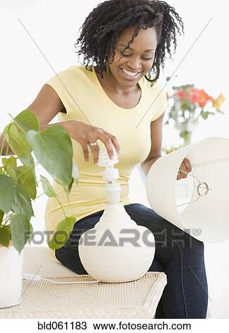 African woman changing light bulb View Large Photo Image Stock Image - African woman changing light bulb. Fotosearch