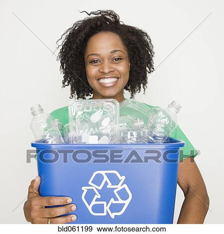 Stock Photo - African woman holding recycling bin. Fotosearch