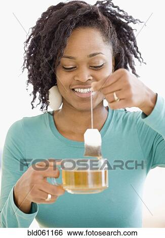 Stock Photograph - African woman holding tea bag. Fotosearch