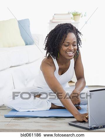 Stock Photograph - African woman looking at laptop. Fotosearch