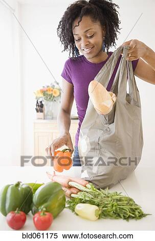 African woman unpacking groceries View Large Photo Image Stock Photography - African woman unpacking groceries. Fotosearch