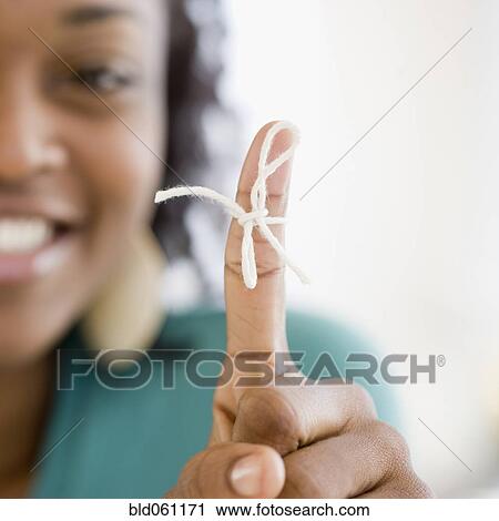 Stock Image - African woman with string tied around finger. Fotosearch