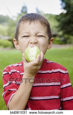 Stock Image - Asian boy eating apple. Fotosearch