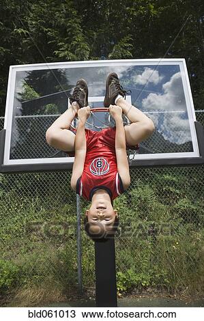 Asian boy hanging upside down on basketball hoop View Large Photo Image Stock Image - Asian boy hanging upside down on basketball hoop. Fotosearch