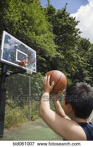 Stock Photo - Asian boy playing basketball. Fotosearch