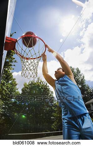 Stock Photo - Asian boy playing basketball. Fotosearch