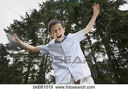 Stock Photo - Asian boy with arms raised. Fotosearch